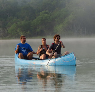 Paddling a Canoe through early morning mist rising from lake