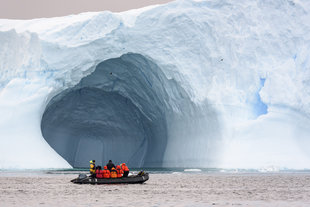 Zodiac Cruising In Front of Huge Iceberg Antarctica