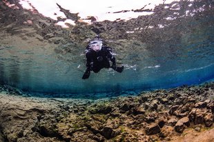 happy-snorkeler-from-below-over-sediment-and-rocks-in-lagoon-by-anders-nyberg-1800x1199.jpg