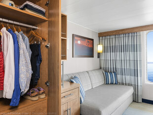 The wardrobe and sofa bed of a Category 5 Cabin